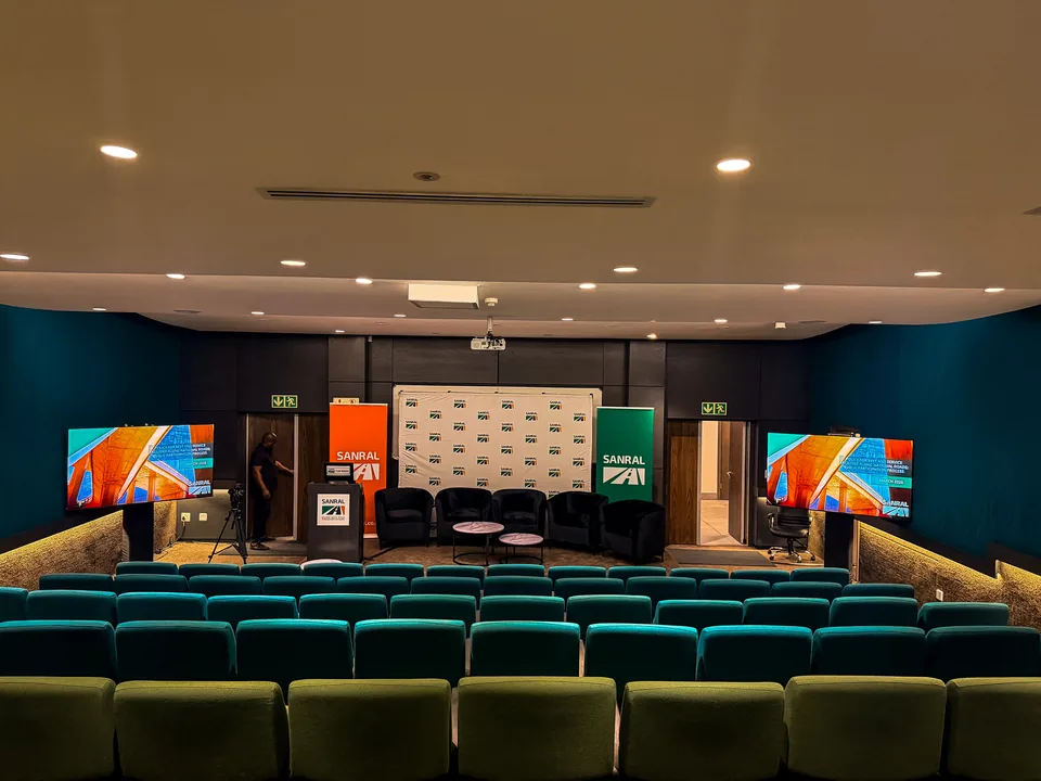 Branded conference stage with presentation screens and seating